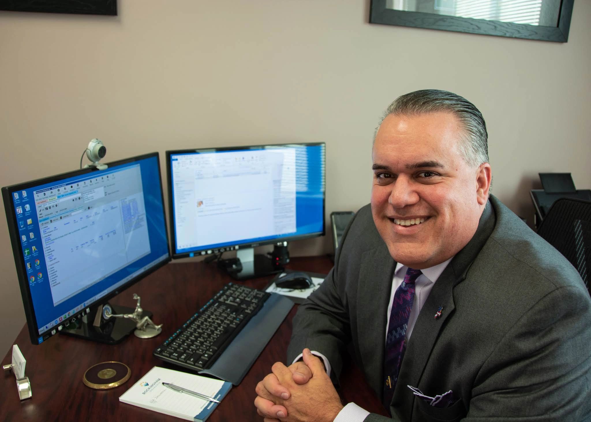 Bob Oveissi at Work: Smiling Insurance Broker, Focused on Hard Work w/ Double Monitor Computer Setup