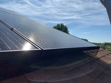 Solar panels installed on a rooftop under a clear blue sky.