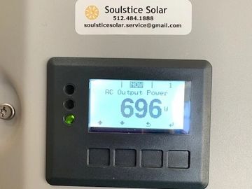 Solar power system displaying 696 watts output power.