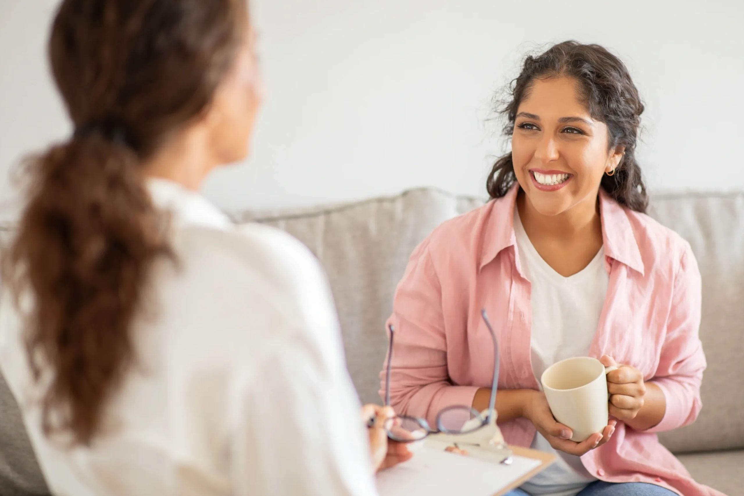 Two people smiling looking at each other one appears to be giving advice 
