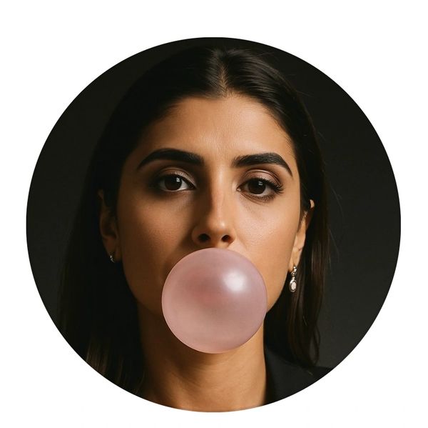 Woman blowing a bubblegum bubble looking directly at the camera.