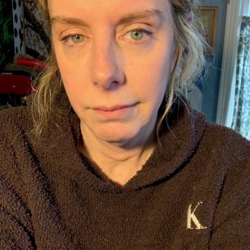 Woman with green eyes wearing a brown fleece hoodie