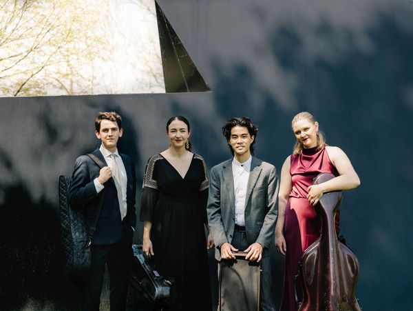 Group of four musicians posing with their instruments.