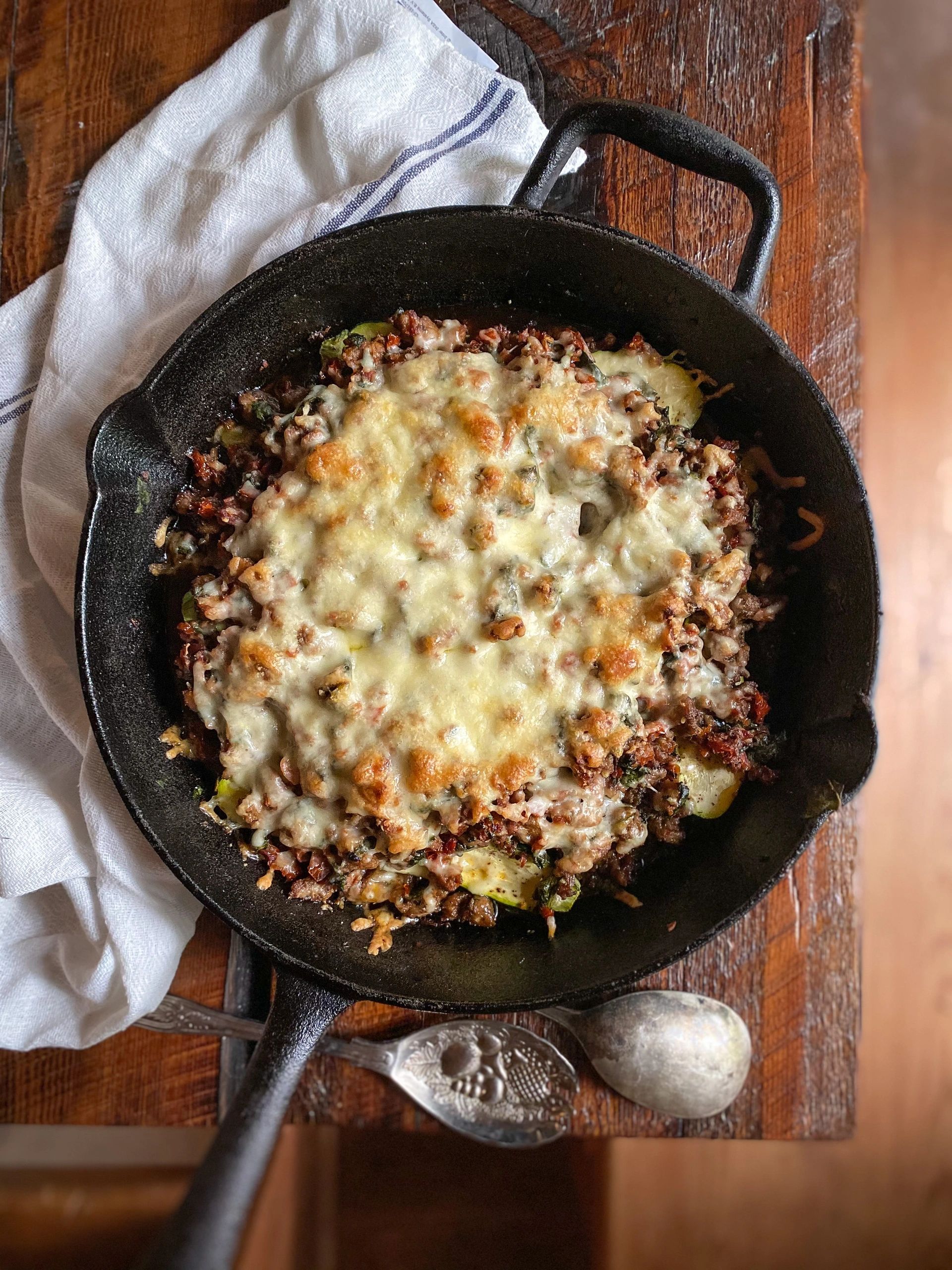 Casserole de courgettes saucisses, tomates séchées et épinards