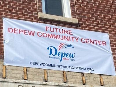 Sign announcing the future Depew Community Center on a brick wall.