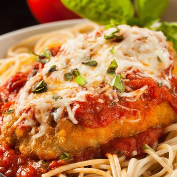 A plate of chicken parmesan with spaghetti and marinara sauce.