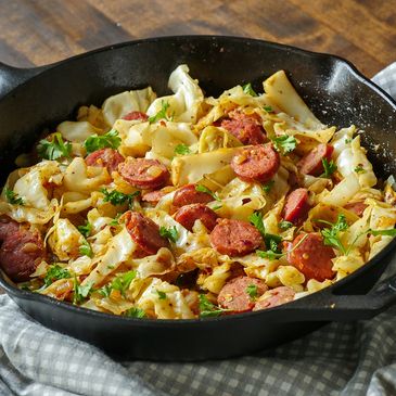 Skillet meal with sausage, cabbage, and fresh herbs.