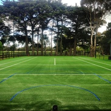 Synthetic turf tennis Court with court lines and basketball key.