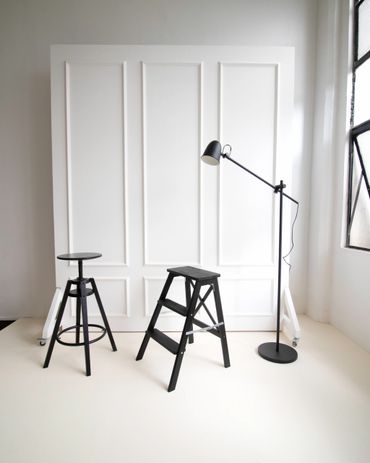 Aesthetic stool, ladder and lamp with white wall.