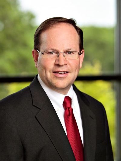 Professional man in suit with red tie and glasses.