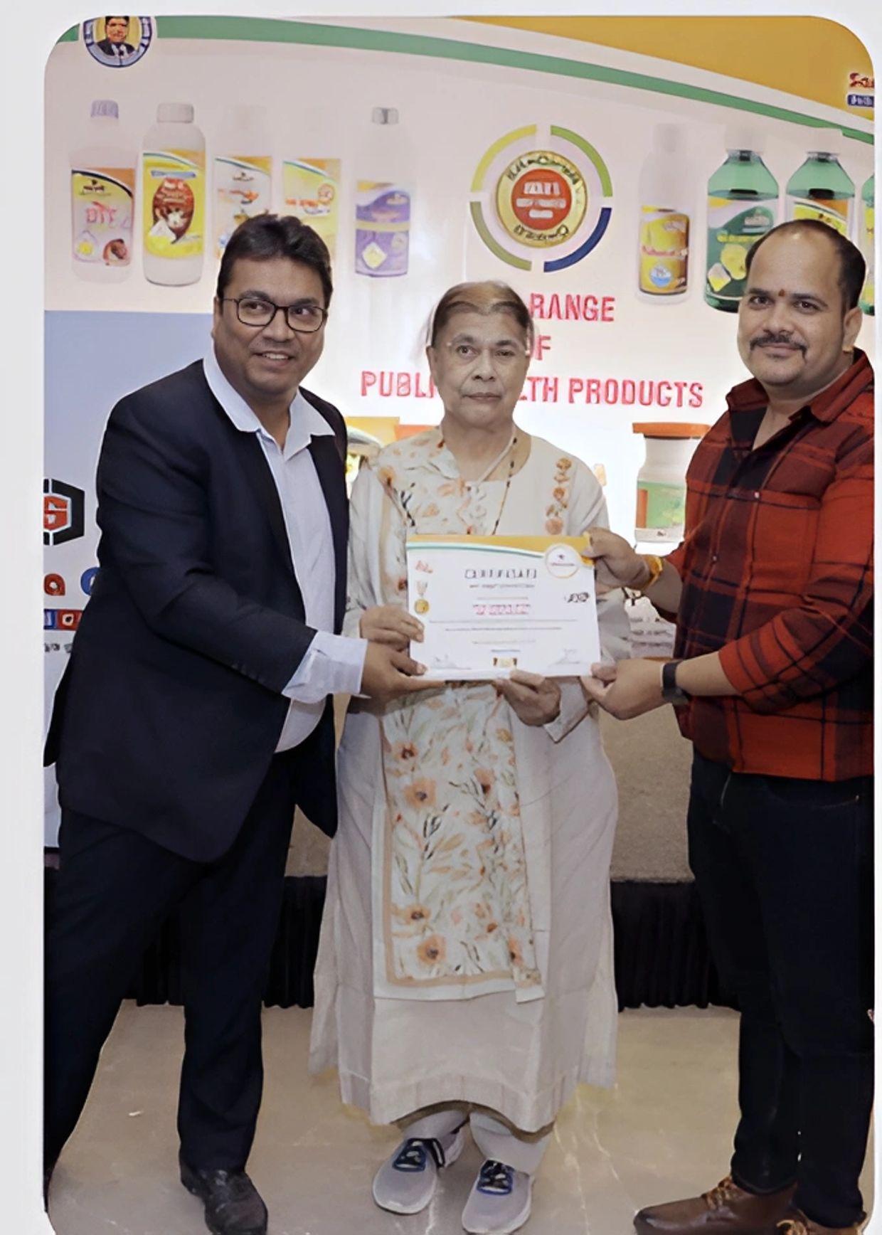 Three people holding a certificate together.