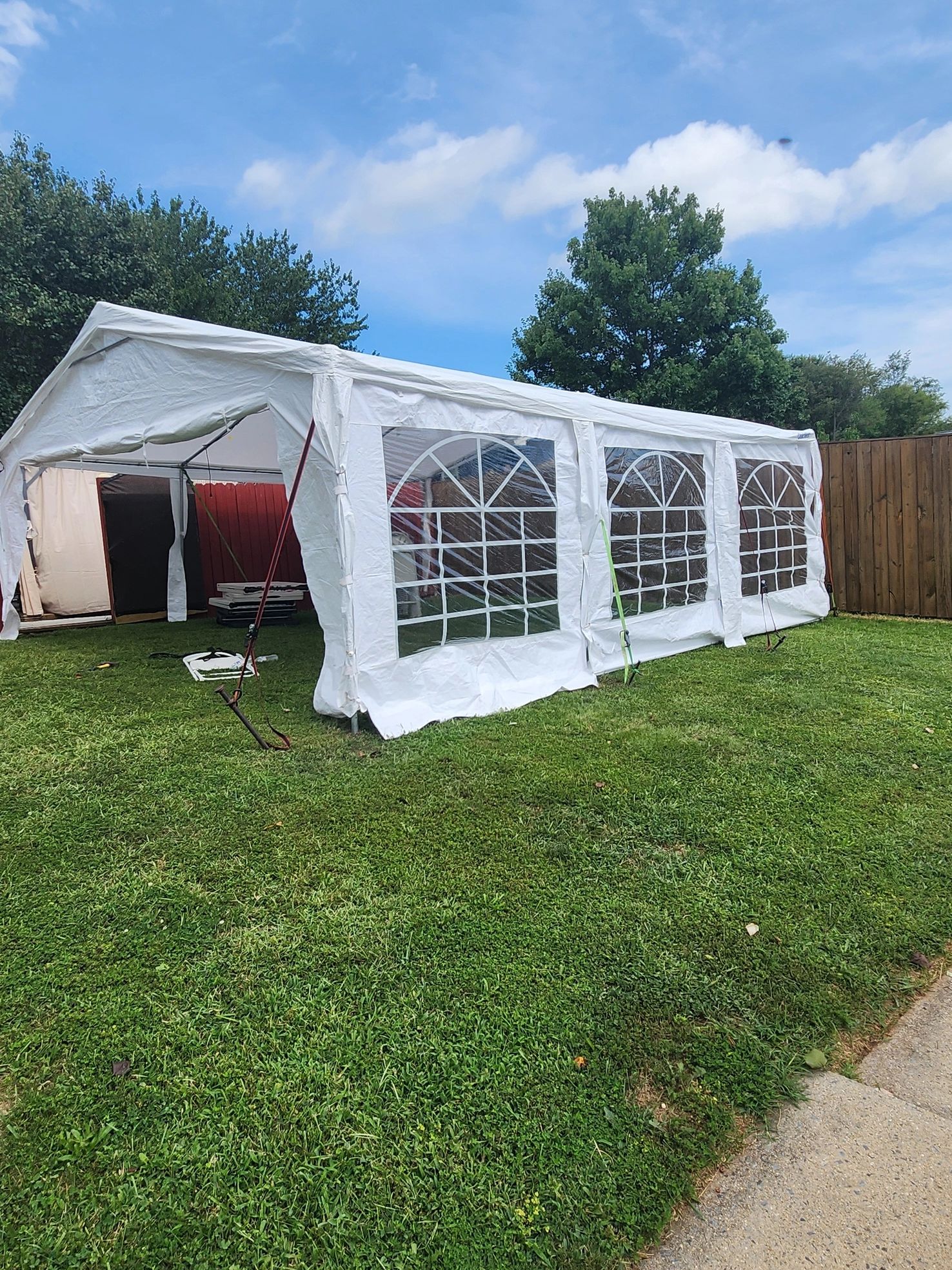 Large white outdoor party tent set up on green grass.