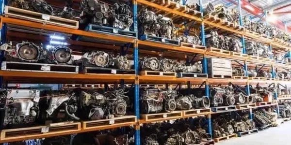 Shelves filled with multiple car engines in a warehouse.