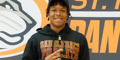 Young man wearing Saddleback Bobcats sweatshirt and cap.