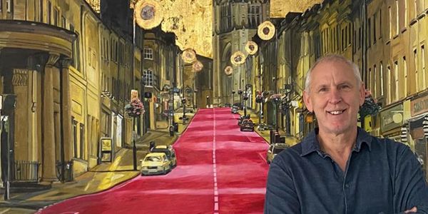 Artist Chris Dickinson smiling in front of Bristol Park Street painting