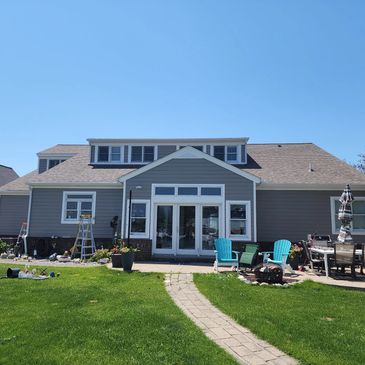 Modern suburban house with a bright lawn and clear sky.