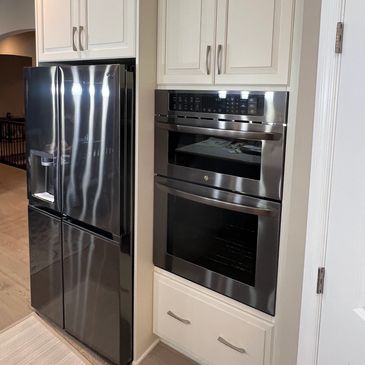 Modern kitchen appliances with white cabinetry.