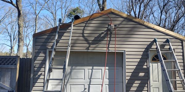 Setup outside a property for roof repair and siding installation.