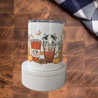 A cup with cute fall-themed drink illustrations and pumpkins.