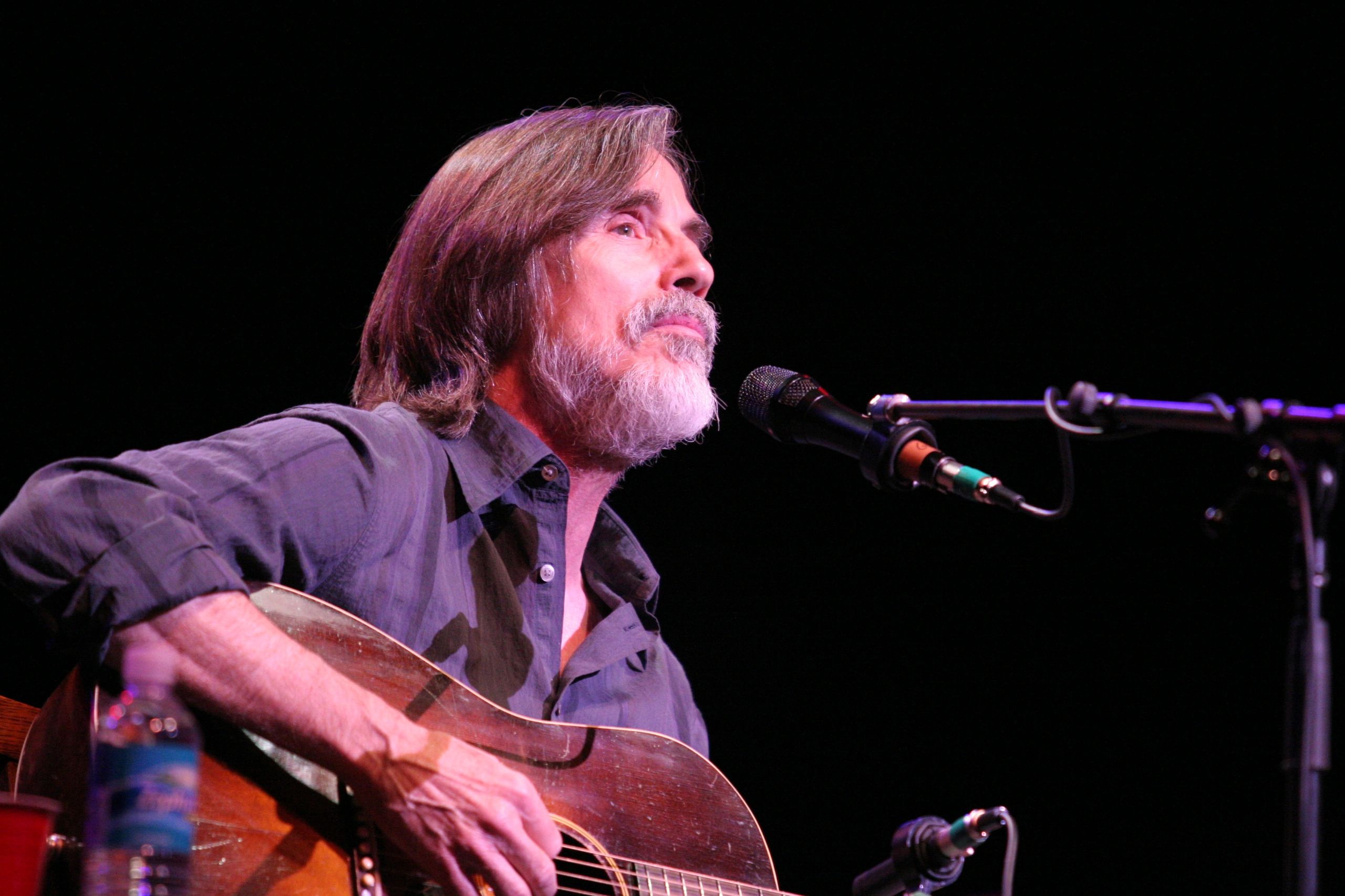Man playing guitar and singing on stage.