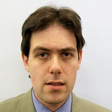 Man with dark hair in formal attire.