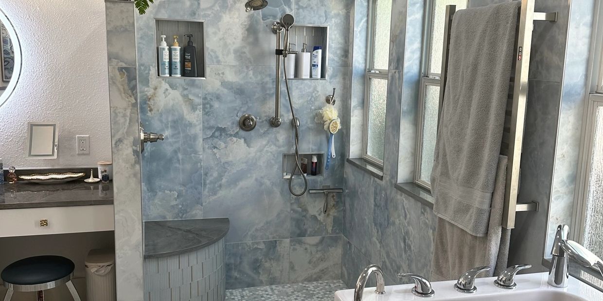 Modern bathroom with blue marble-like tiles and chrome fixtures.