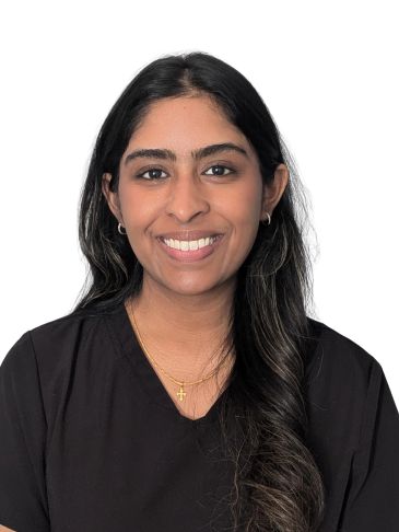 Smiling woman with long dark hair wearing a black top and gold necklace.
