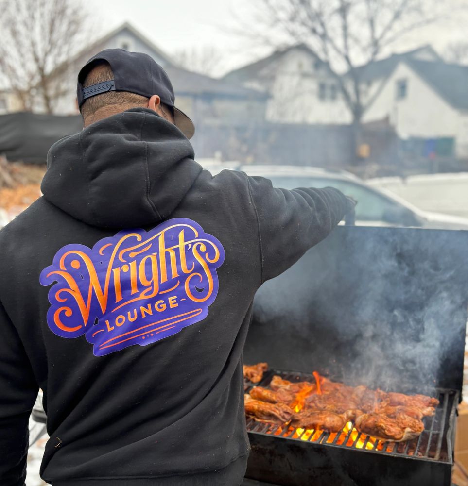Black man on a grill with sweatshirt that says Wright's Lounge BBQ PMA
