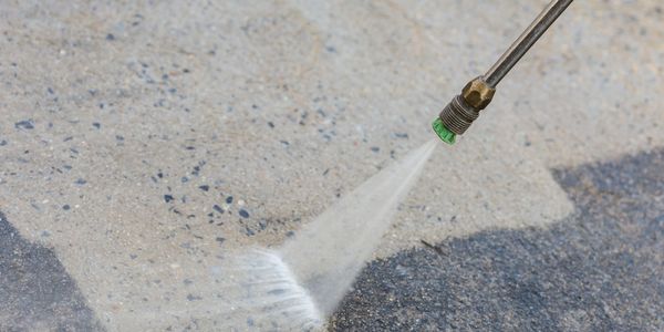 Person power washing a concrete floor
