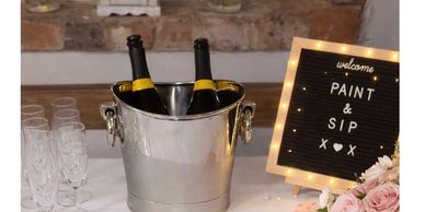 Elegant setup for a Paint & Sip event with champagne, flowers, and welcoming decor.