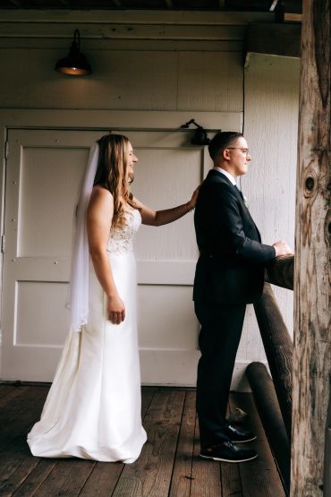 Bride gently touches groom's shoulder during a wedding moment.