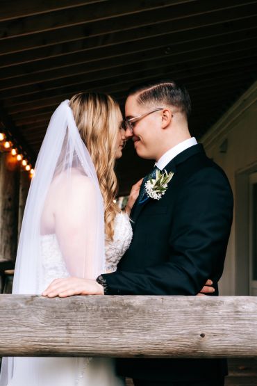 Bride and groom touching foreheads, sharing an intimate moment.
