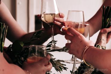Friends clinking wine glasses in a warm, intimate gathering.