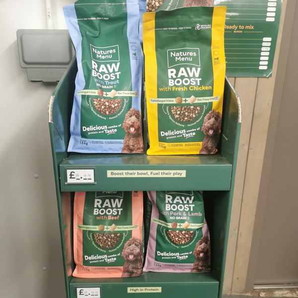 Display of Natures Menu Raw Boost dog food bags in various flavors.