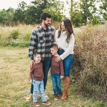 Happy family of four enjoying time outdoors in autumn.