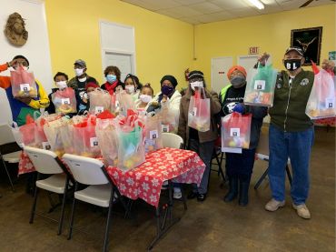 Group of people holding gift bags in a festive setting.