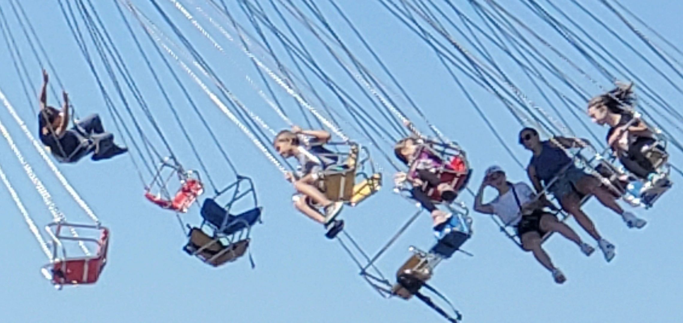 People enjoying a swing ride at an amusement park.