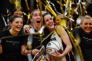 A joyful group of female basketball players celebrating with confetti.