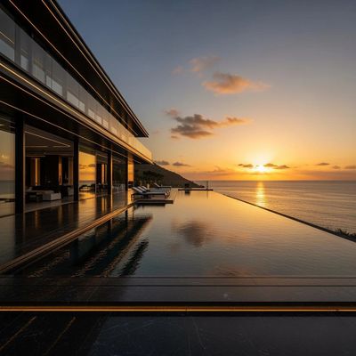 Modern house with infinity pool overlooking ocean sunset.