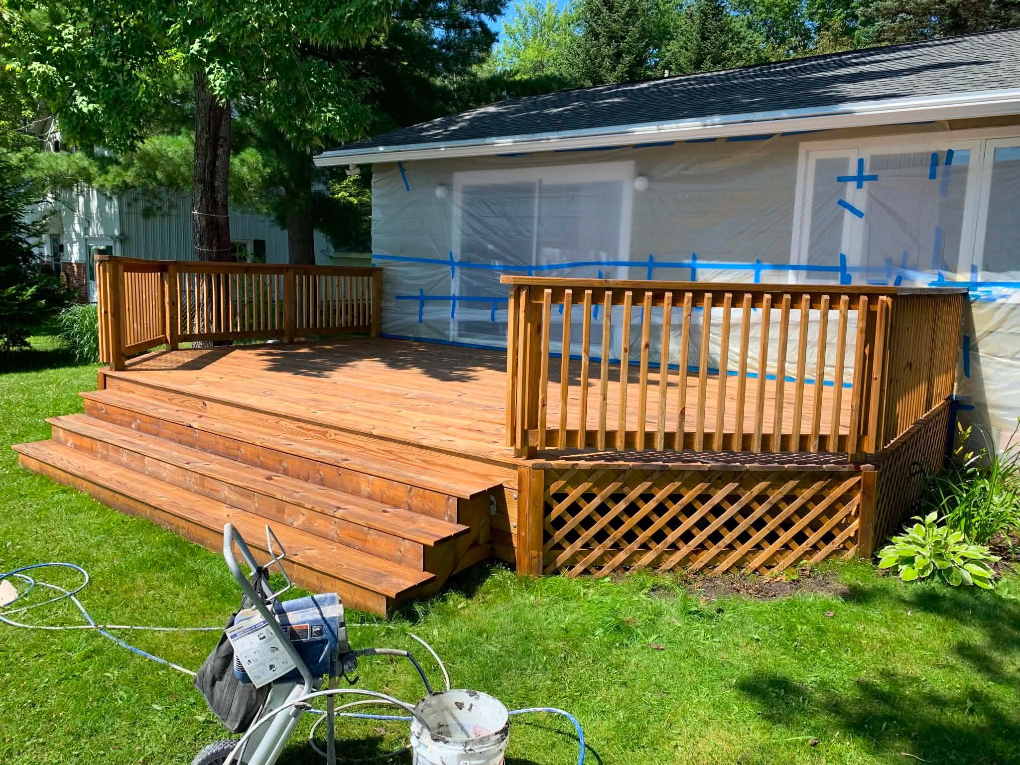 Newly built wooden deck with house covered for painting.