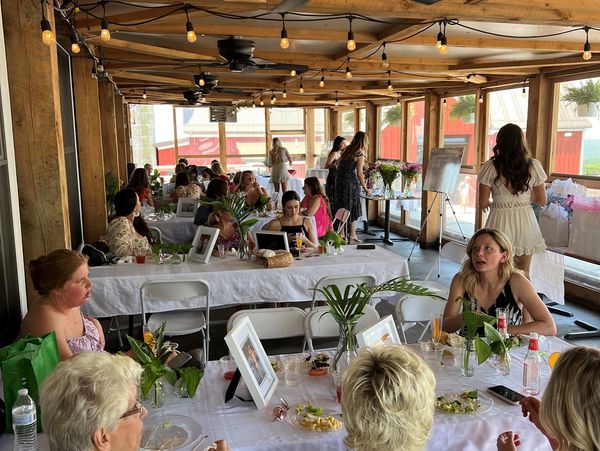 People gathered for a daytime event in a wooden pavilion.