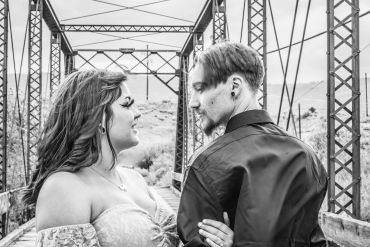 Couple looking at each other on a bridge.