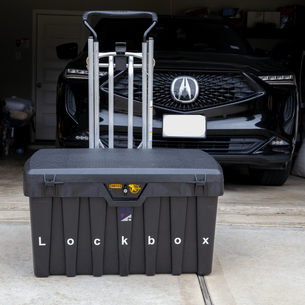 Black lockbox with a trolley handle in front of a black Acura SUV in a garage.