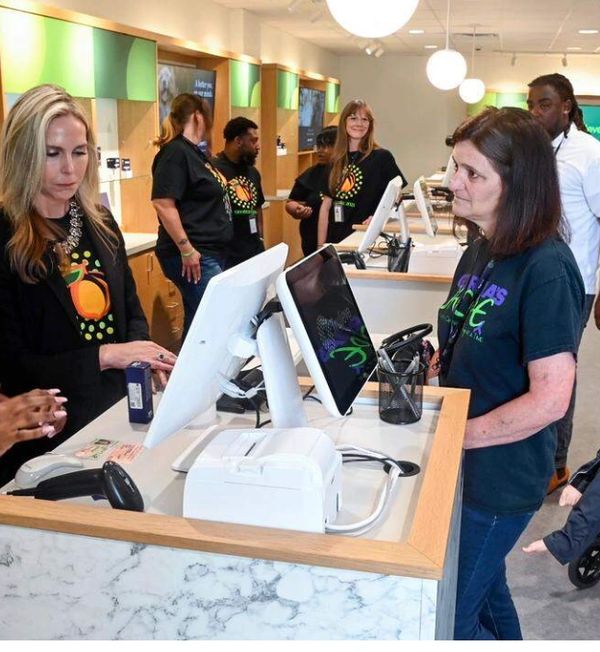 Customers and staff interacting at a modern retail checkout counter.