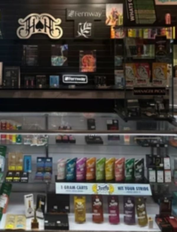 Display of colorful cannabis product packaging and accessories at a store counter.