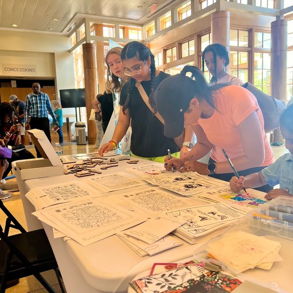 People coloring and engaging in an arts and crafts activity at a community event.