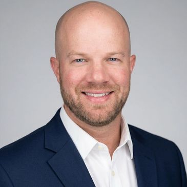 Smiling bald man in business attire.