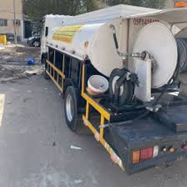A white tanker truck parked on a street.