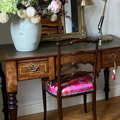 Re upholstered chair with antique desk.
