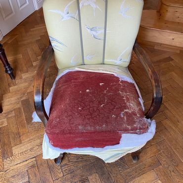 Worn-out vintage chair with torn seat upholstery.